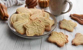 biscoitos em forma de abóbora e folhas em fundo de madeira rústica foto