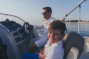 pai e filho aproveitam as férias juntos enquanto andam em um barco de luxo no mar. foco seletivo foto