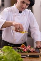 chef terminando o prato de carne de bife foto