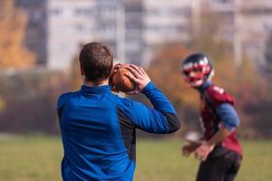 time de futebol americano com treinador em ação foto