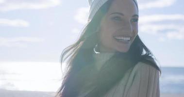 garota com roupas de outono sorrindo na praia foto