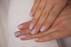 dedos de mulher com manicure francesa foto