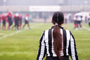 vista traseira do árbitro de futebol americano feminino foto