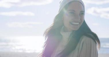 garota com roupas de outono sorrindo na praia foto