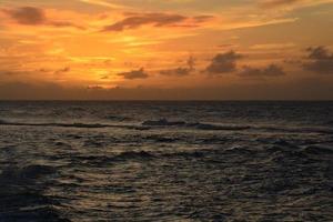 pôr do sol laranja sobre o oceano foto