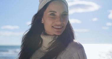 garota com roupas de outono sorrindo na praia foto