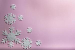 composição de natal ou inverno. padrão feito de flocos de neve em fundo rosa pastel. foto