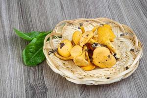 chanterelle em uma cesta em fundo de madeira foto