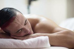 homem bonito descansando em um centro de massagem spa foto