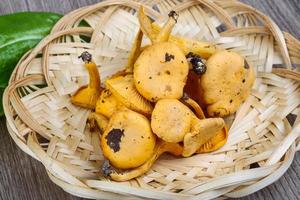 chanterelle em uma cesta em fundo de madeira foto