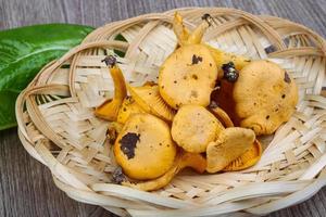 chanterelle em uma cesta em fundo de madeira foto