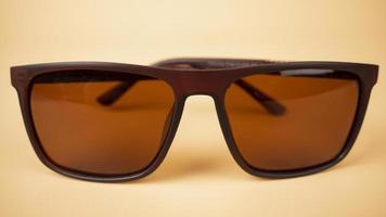 óculos de segurança polarizados do sol closeup em fundo bege foto