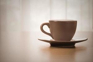 xícara de café na mesa de madeira, estilo vintage foto