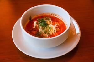 sopa de tomate em uma tigela com fundo de madeira foto