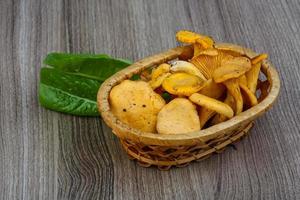 chanterelle em uma cesta em fundo de madeira foto