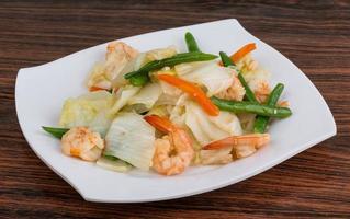 salada de camarão no prato e fundo de madeira foto