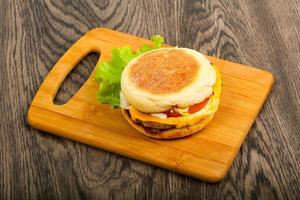 cheeseburger na tábua de madeira e fundo de madeira foto