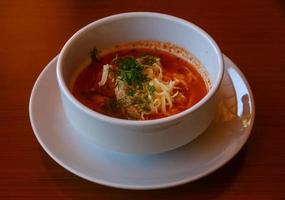 sopa de tomate em uma tigela com fundo de madeira foto