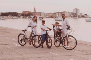 a família feliz desfruta de uma bela manhã à beira-mar andando de bicicleta juntos e passando tempo juntos. o conceito de uma família feliz foto