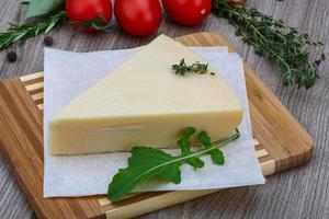 queijo parmesão na tábua de madeira e fundo de madeira foto