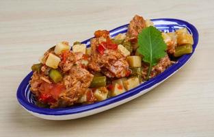 salada nicoise em uma tigela sobre fundo de madeira foto