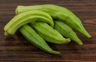 legumes de quiabo na madeira foto