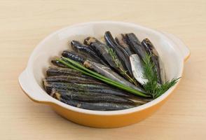 anchova salgada em uma tigela sobre fundo de madeira foto