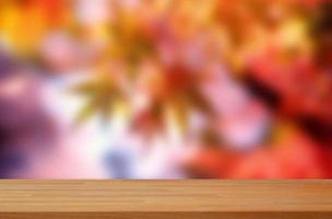 mesa de madeira vazia em folhas de outono ao ar livre em maquete de exibição de produto de fundo branco foto