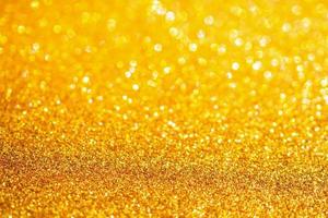 brilho de glitter dourado com fundo bokeh foto