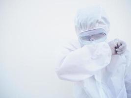 médico masculino asiático ou cientista em uniforme de suíte de EPI mostrando esse sentimento strees e triste. coronavírus ou covid-19 conceito isolado fundo branco foto