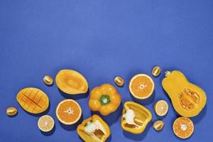 coleção de frutas e legumes amarelos frescos no fundo azul foto