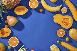 coleção de frutas e legumes amarelos frescos no fundo azul foto