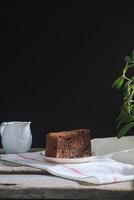 conceito de café de fermentação por gotejamento. mesa de madeira com bolo de chocolate e café em fundo preto. foto