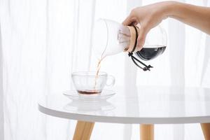 fabricação de café por gotejamento nel. instruções de cozimento passo a passo. o café está pronto. barista derramando café na xícara foto
