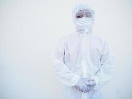 retrato de jovem médico asiático ou cientista em uniforme de suíte de ppe segurando as mãos enquanto olha para a frente. coronavírus ou covid-19 conceito isolado fundo branco foto