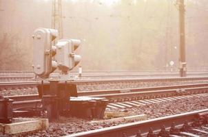 foto de um fragmento de uma ferrovia com um pequeno semáforo em tempo chuvoso