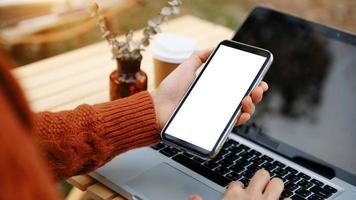 empresária profissional segurando um smartphone de tela em branco na sala de escritório moderna foto