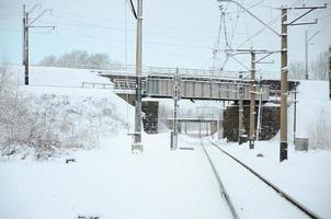 paisagem ferroviária de inverno, trilhos ferroviários no país industrial coberto de neve foto