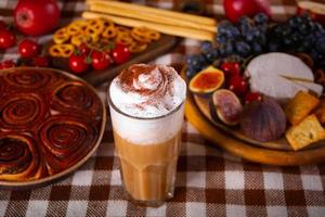 tempero de abóbora batido com leite em vidro. bebida quente de outono. nas proximidades deliciosas tortas e aperitivos frutas e queijos. foto