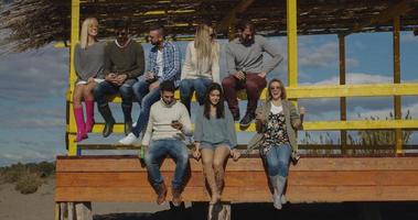 grupo de amigos se divertindo no dia de outono na praia foto