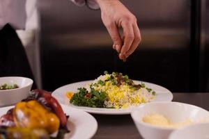 mãos de chef servindo risoto de legumes foto