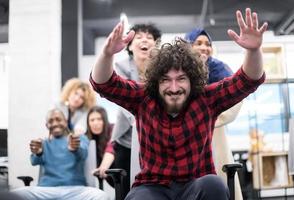 equipe de negócios multiétnica competindo em cadeiras de escritório foto