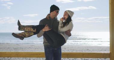 casal se divertindo em lindo dia de outono na praia foto