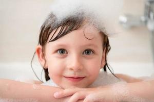 menina no banho brincando com espuma foto