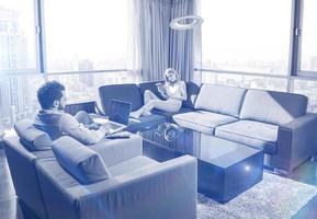 casal relaxando em casa usando tablets e laptops foto