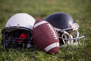 capacetes de futebol americano e bola foto