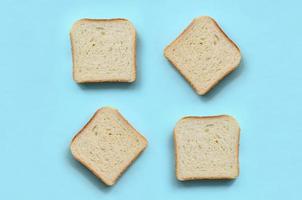 alguns pedaços de pão estão no fundo de textura de papel de cor azul pastel de moda em conceito mínimo foto