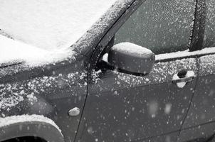 fragmento do carro sob uma camada de neve após uma forte nevasca. o corpo do carro está coberto de neve branca foto