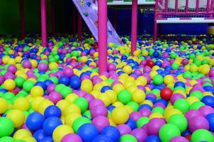 muitas bolas de plástico coloridas em uma piscina infantil em um playground foto