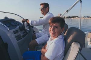 pai e filho aproveitam as férias juntos enquanto andam em um barco de luxo no mar. foco seletivo foto